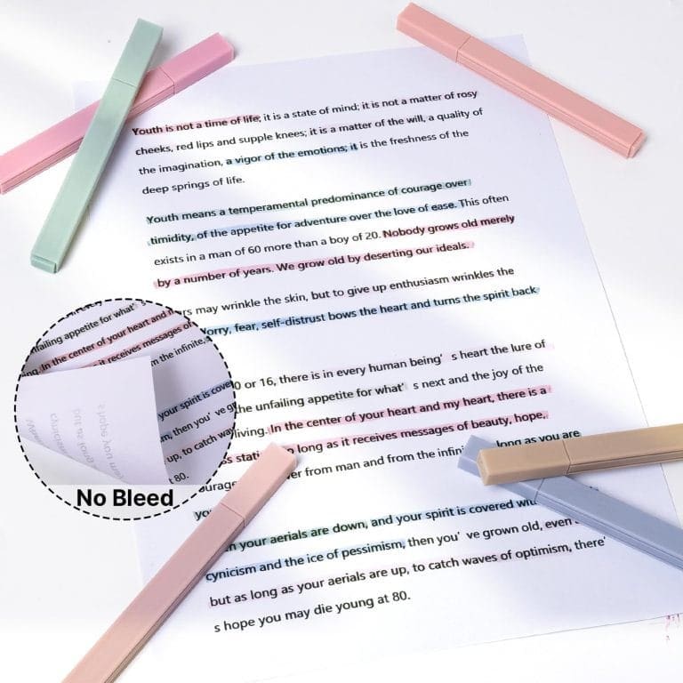 Close-up of a printed page with a magnifying glass on it, surrounded by pastel pink and teal highlighter pens.